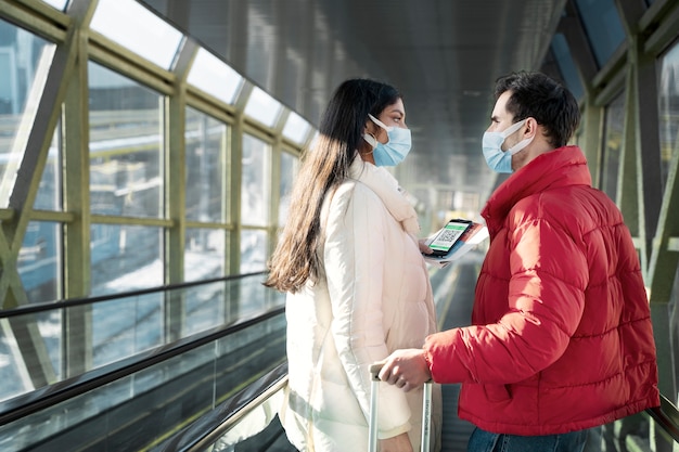 Foto pareja viajando con pasaportes de vacunación.