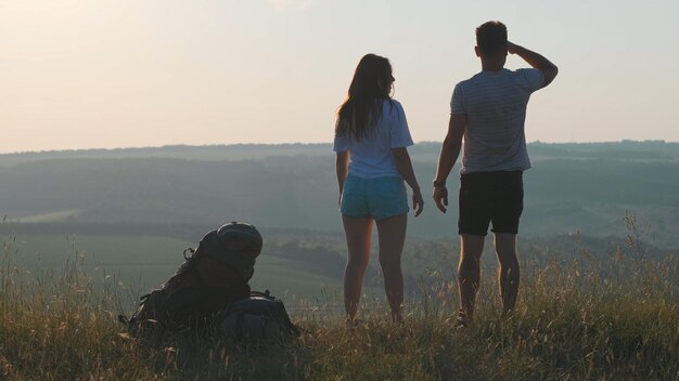 La pareja de viajeros de pie en la cima de la montaña.