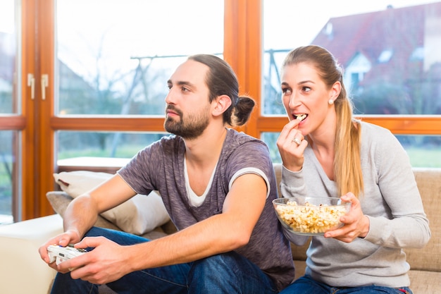 Foto pareja de videojuegos y palomitas de maíz.