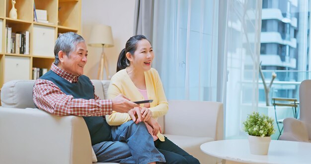 Una pareja vieja mira la televisión.
