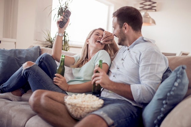 Pareja viendo la televisión y comiendo palomitas de maíz