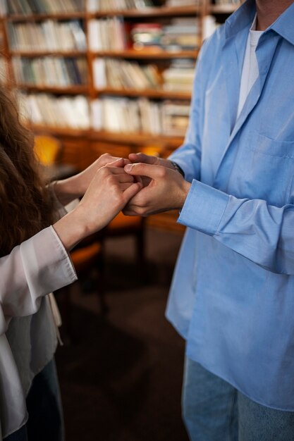 Foto pareja de vista lateral que tiene una cita en la librería