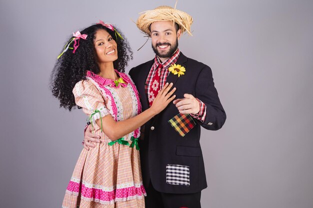 Pareja vistiendo ropa típica de Festa Junina Arraial Festa de Sao Joao apuntando a la cámara