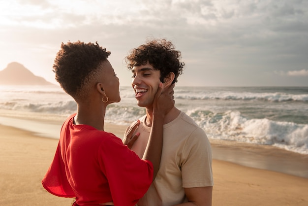 Foto parejas abrazándose cerca del mar