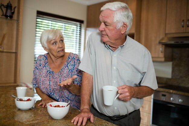 Las parejas ancianas discutiendo en la cocina de casa