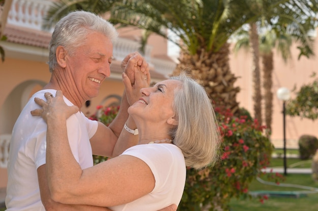 Las parejas ancianas se divierten en el jardín del hotel tropical