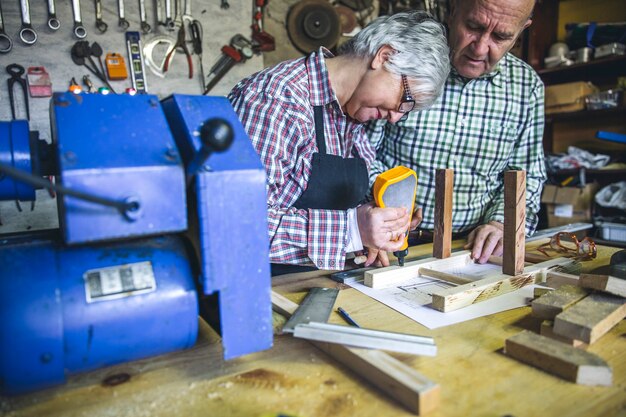 Las parejas ancianas que trabajan en un taller de carpintería