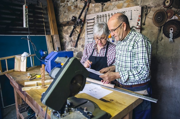Las parejas ancianas que trabajan en un taller de carpintería