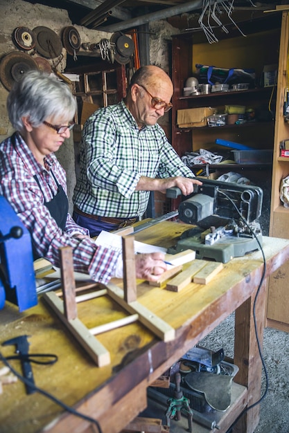 Las parejas ancianas que trabajan en un taller de carpintería