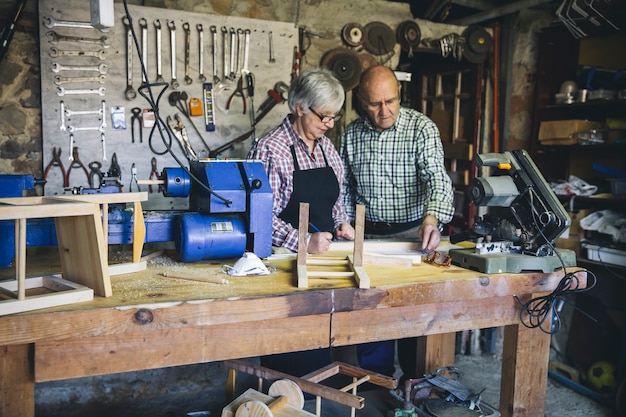 Foto las parejas ancianas que trabajan en un taller de carpintería