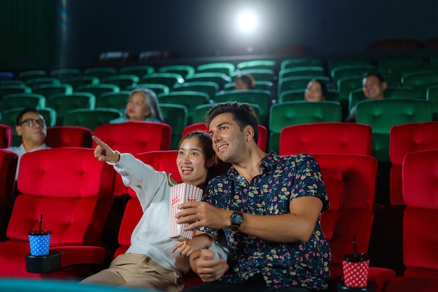 Las parejas disfrutan de las películas mientras sostienen palomitas de maíz, creando una experiencia nocturna de cine acogedora y entretenida.