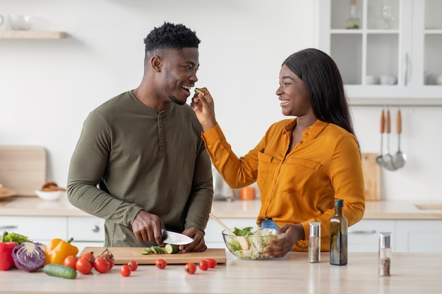 Parejas estilo de vida romántico negro hombre y mujer cocinando comida en la cocina juntos