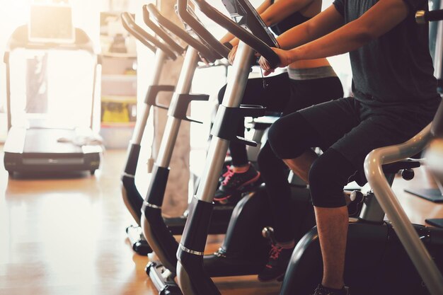 Foto las parejas hacen ejercicio para una buena salud montando en bicicleta en el gimnasio.