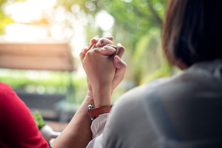 Foto las parejas jóvenes se dan la mano mientras están sentados juntos en casa, con las manos enfocadas.