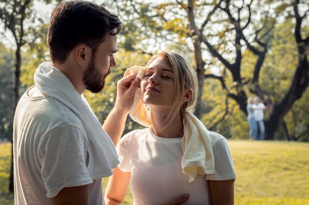 Las parejas jóvenes se limpian el sudor después de hacer ejercicio.