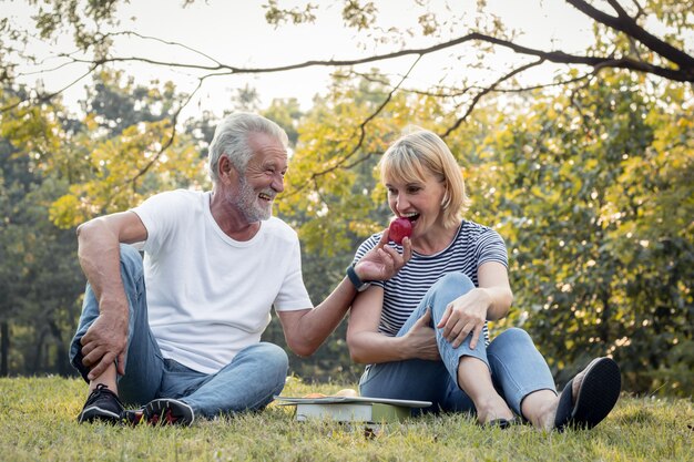 Las parejas mayores se dan manzanas juntas felizmente.