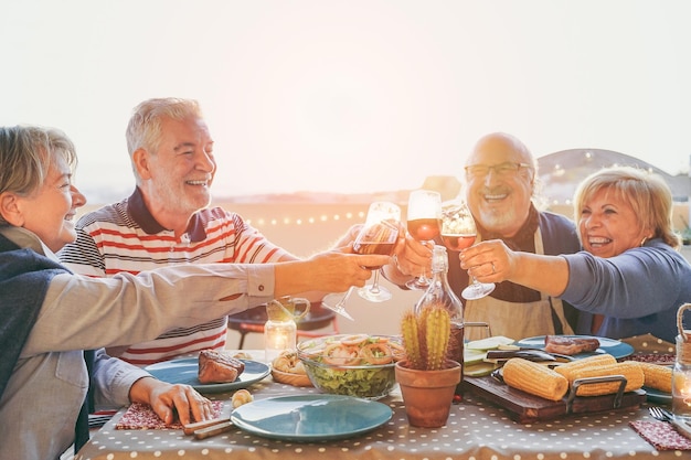 Foto parejas mayores felices con copas de vino en la terraza del edificio