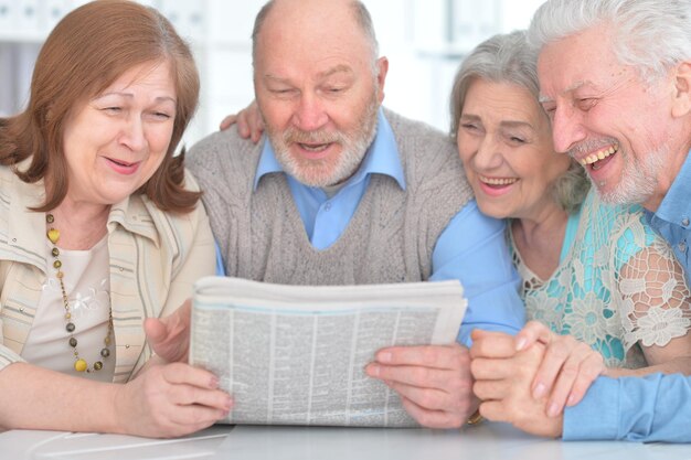 Parejas mayores leyendo el periódico