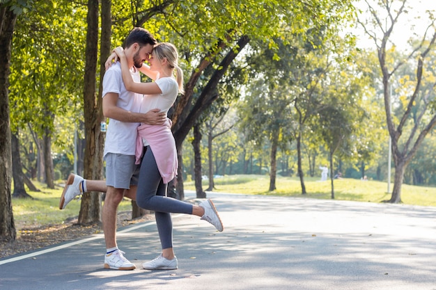 Parejas de pie besos y abrazos en el parque.