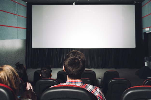 Parejas sin rostro mirando la pantalla del cine