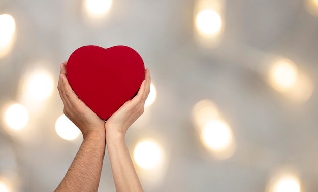 Parejas sosteniendo caja en forma de corazón