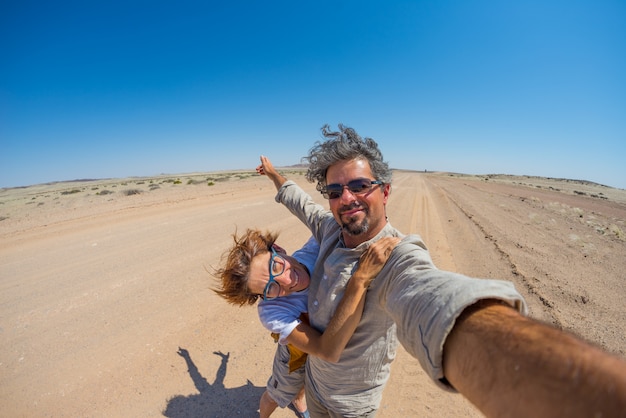 Pares adultos que tomam o selfie no deserto de Namib, parque nacional de Namib Naukluft, Namíbia, África.