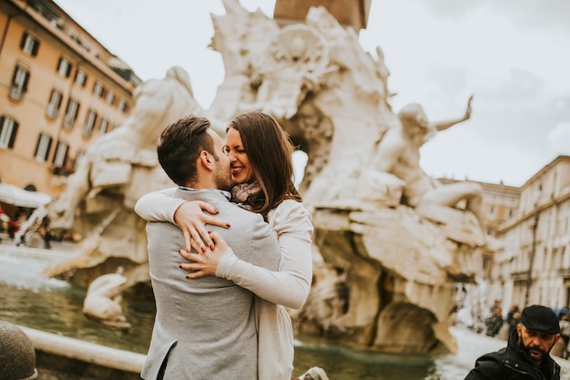 Pares cariñosos que hacen turismo en vacaciones del viaje en Roma, Italia