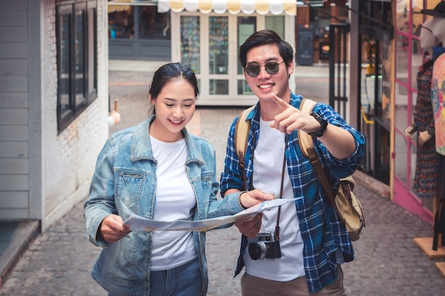 Foto pares de viajantes que usam o mapa para sightseeing na cidade. retrato, de, jovem, sorrindo, turista, homem, e, wom