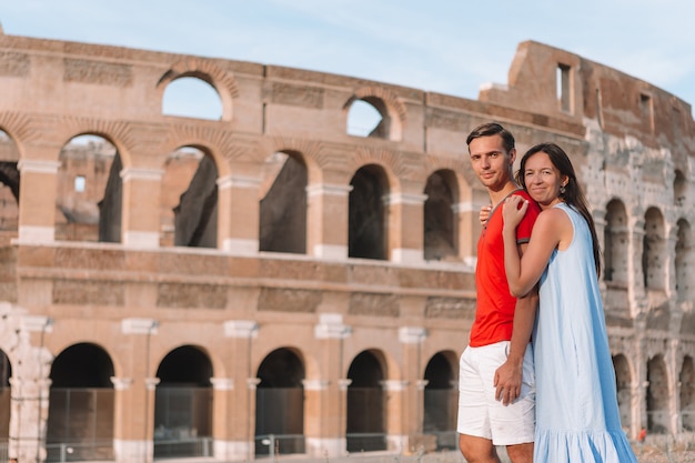 Pares felizes em Roma sobre o fundo do coliseu. Férias européias italianas