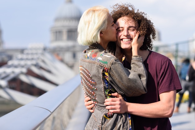 Pares felizes que abraçam pela ponte do milênio, rio Tamisa, Londres.