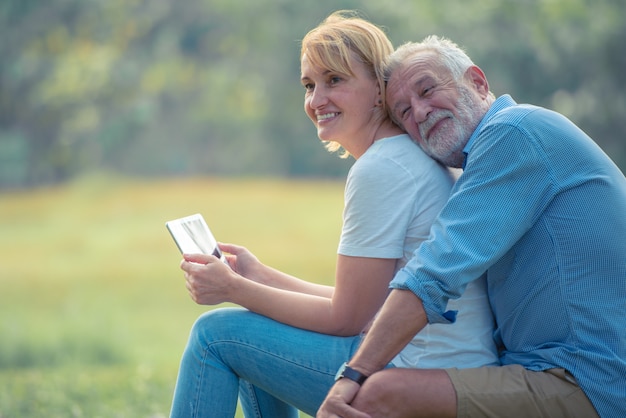 Pares idosos felizes que apreciam passar o tempo junto, abraçando, falando com cara de sorriso e rindo