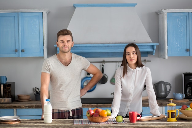 Pares jovenes felices en la cocina por la mañana.