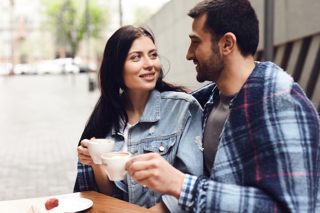 Pares de la luna de miel en el café envuelto en la manta acogedora.