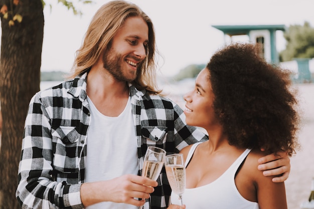 Pares multirraciais românticos Champagne na praia.