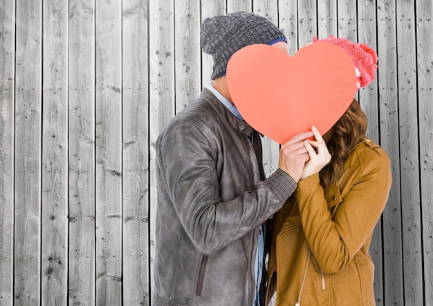 Foto pares románticos que ocultan su cara detrás del corazón