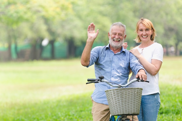 Pares superiores que andam sua bicicleta longitudinalmente felizmente falando felizmente.