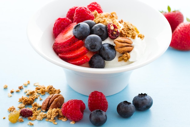 Parfait com frutas frescas e granola em tigela branca.