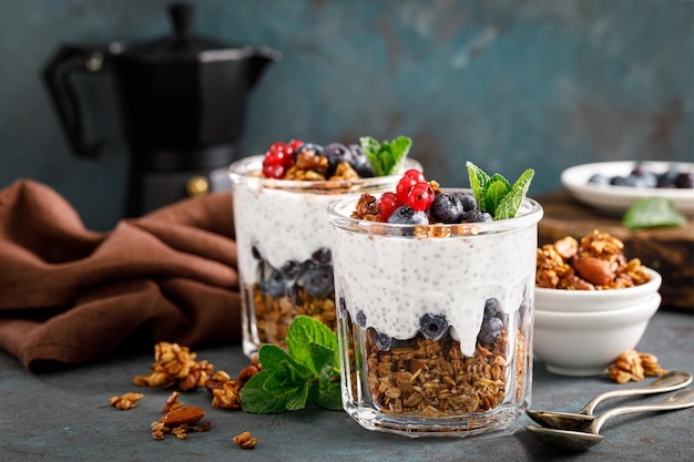 Parfait de mirtilo e groselha em camadas com granola de aveia caseira de iogurte chia e frutas frescas no café da manhã