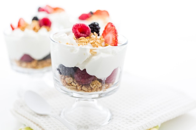 Parfait de desayuno elaborado con yogur griego y granola cubierto con bayas frescas.