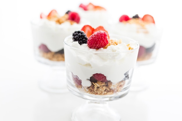 Parfait de desayuno elaborado con yogur griego y granola cubierto con bayas frescas.