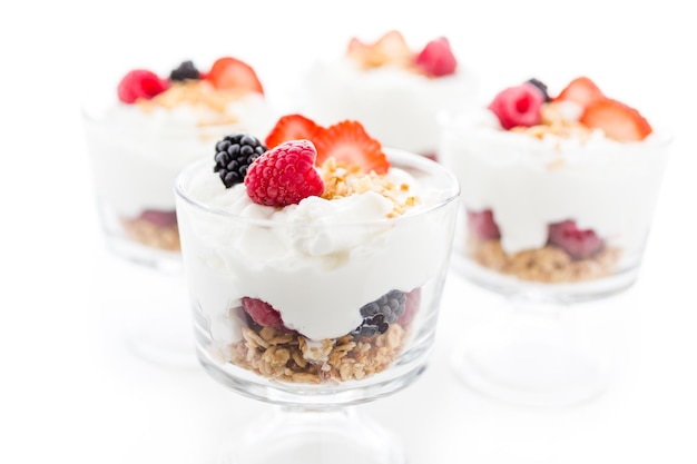 Parfait de desayuno elaborado con yogur griego y granola cubierto con bayas frescas.