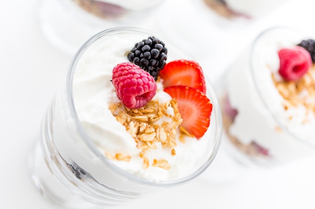 Parfait de desayuno elaborado con yogur griego y granola cubierto con bayas frescas.