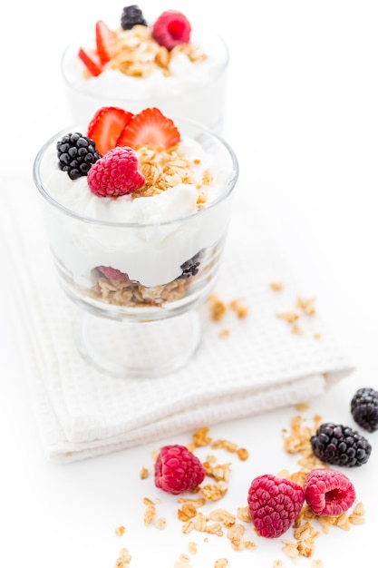 Parfait de desayuno elaborado con yogur griego y granola cubierto con bayas frescas.