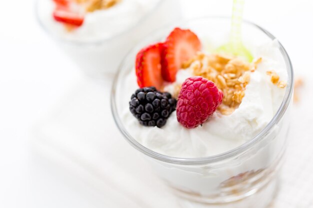 Parfait de desayuno elaborado con yogur griego y granola cubierto con bayas frescas.