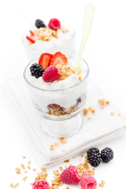 Parfait de desayuno elaborado con yogur griego y granola cubierto con bayas frescas.