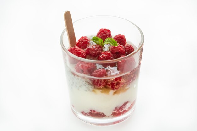 Parfait hecho de yogur griego con frambuesa, menta y chía en un blanco. Postres Saludables.