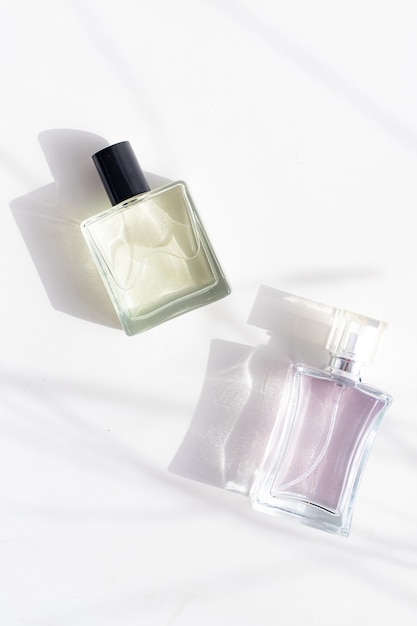 Parfüm auf einer weißen Fläche mit Schatten. Die Wahl des Parfüms. Aromatherapie.