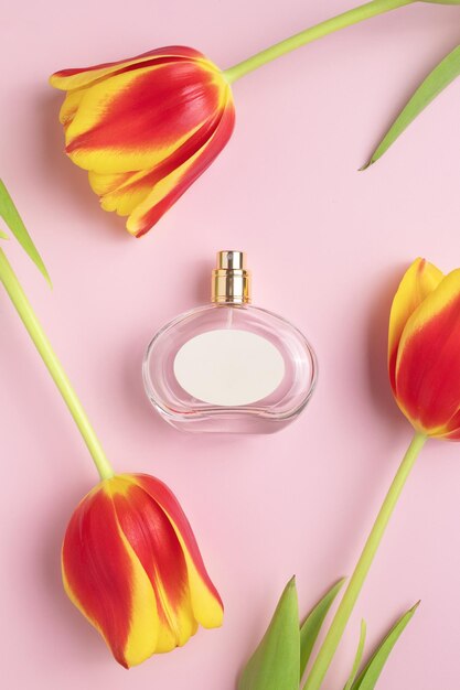 Parfümflasche mit weißem Etikett und Tulpenblumen Konzept von teurem Parfüm und Kosmetik Blumiger Duft für Frauen Parfümspray Moderne Luxusdame parfum de toilette