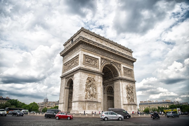 París, Francia - 02 de junio de 2017: Arc de Triomphe en el cielo nublado. Monumento de arco en el centro de la concurrida plaza. Vacaciones y turismo en la capital francesa. Victoria, liberación y concepto de honor.