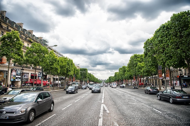 París Francia 02 de junio de 2017 Avenue des Champs Elysees con mucho tráfico Elysian fields road en cielo nublado Vacaciones y viajes en la capital francesa